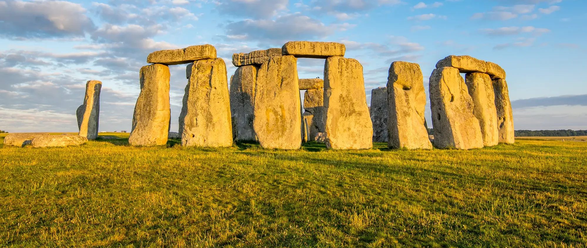 A photo of stonehenge - a ring of ancient stone pillars on a hilltop